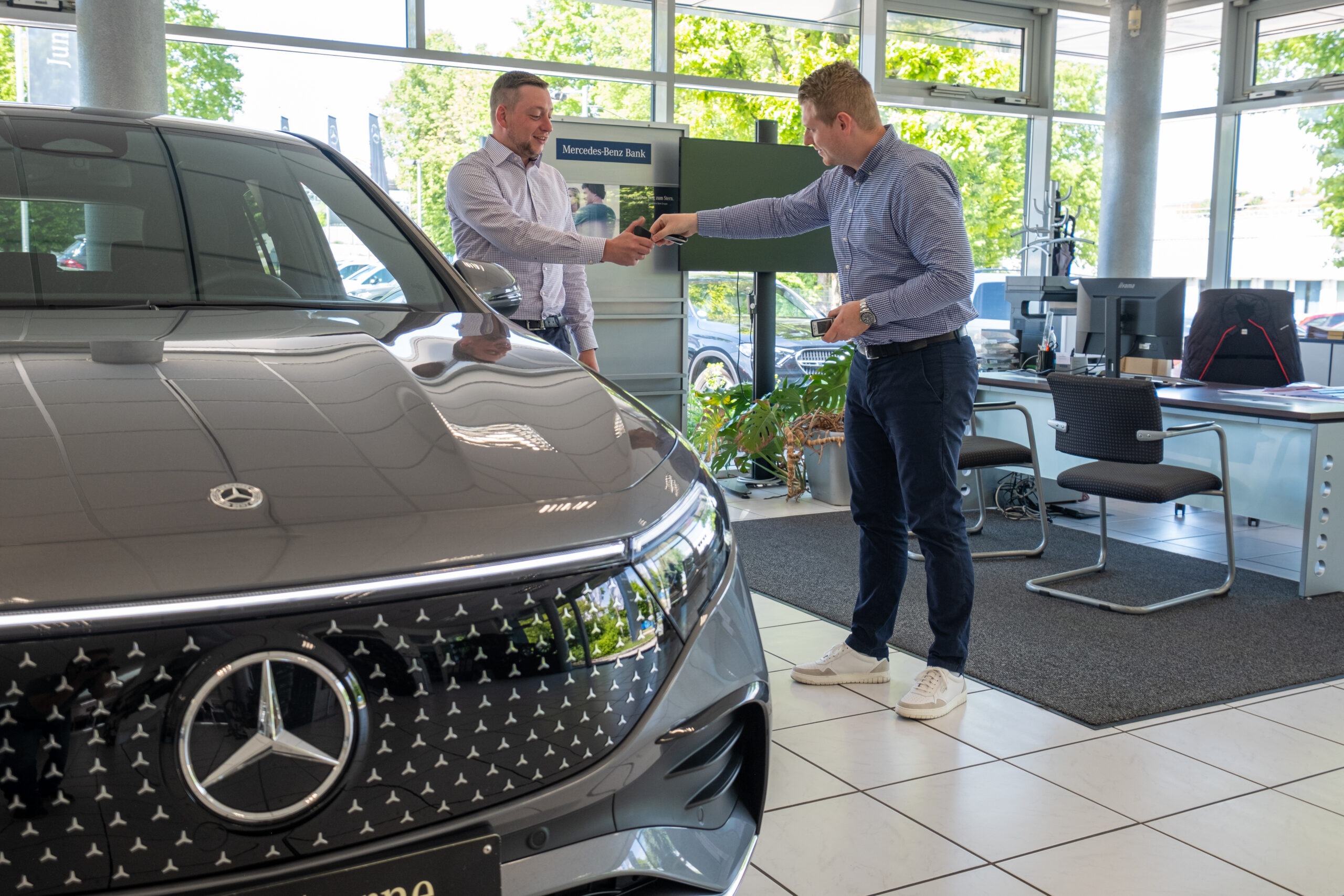 Schlüsselübergabe im Autohaus Franz Schmid – Mitarbeitender übergibt Fahrzeugschlüssel an Kundin/Kunden